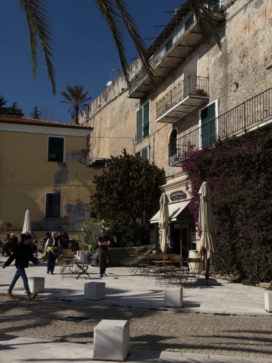Piazza in der historischen Altstadt von Ventimiglia mit Palme, Bougainvillea und traditionellen Häusern